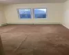 Spare room featuring a healthy amount of sunlight, carpet floors, and baseboard heating