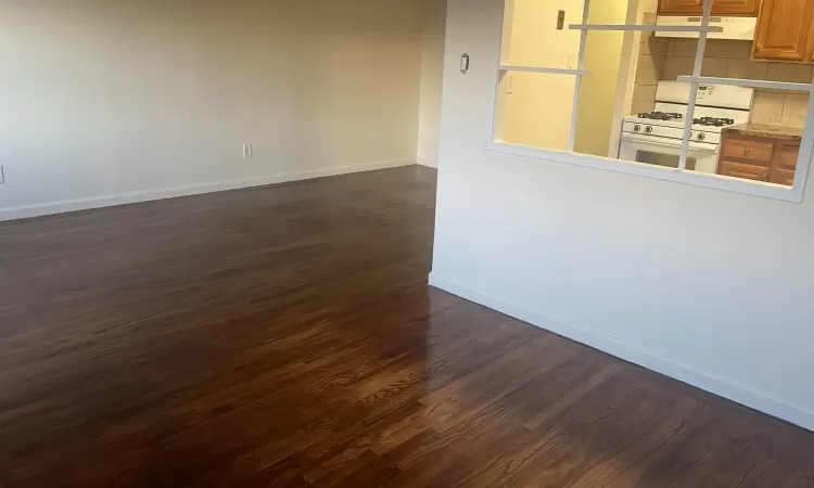 Empty room with dark hardwood / wood-style floors