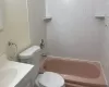 Full bathroom with tiled shower / bath, vanity, and toilet