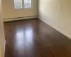 Empty room with baseboard heating and dark hardwood / wood-style floors