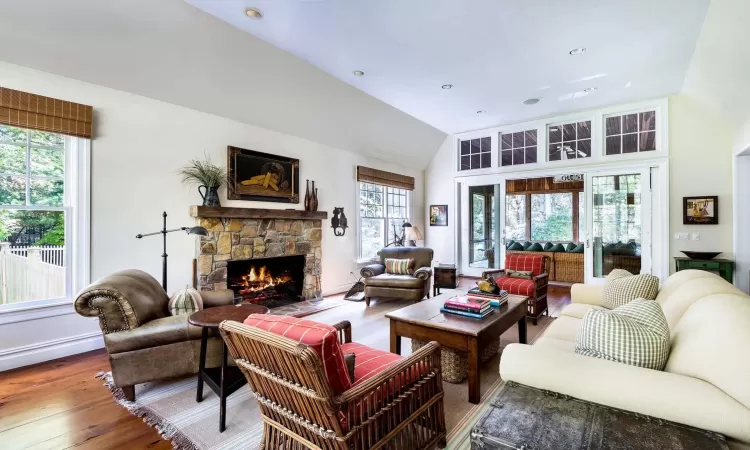 Living room featuring lofted ceiling, a fireplace, and hardwood / wood-style floors