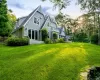 Back house at dusk featuring a lawn