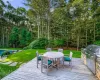 Wooden terrace with an outdoor kitchen, a yard, and area for grilling