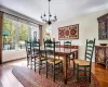 Dining area with hardwood / wood-style flooring, ornamental molding, and an inviting chandelier