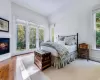 Bedroom with vaulted ceiling, multiple windows, and access to outside