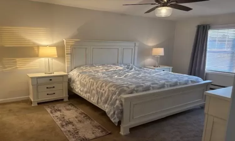 Bedroom featuring ceiling fan and dark carpet