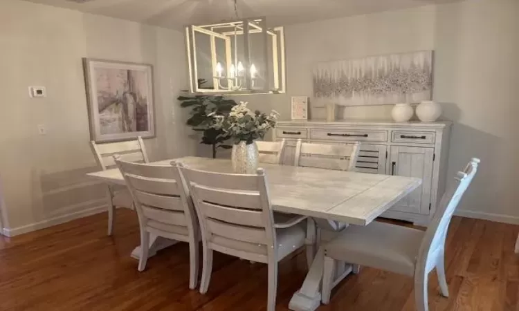 Dining area featuring an inviting chandelier and dark hardwood / wood-style floors