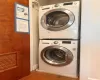 Laundry room featuring stacked washer / drying machine and hardwood / wood-style flooring