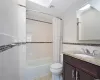 Full bathroom featuring vanity, toilet, tile walls, and shower / bath combo with shower curtain