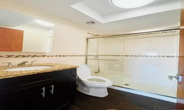 Ensuite Bathroom featuring vanity, toilet, an enclosed shower