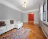 Living room featuring a healthy amount of sunlight, radiator, parquet floors, and a notable chandelier