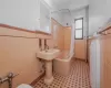 Bathroom featuring shower / tub combo with curtain, toilet, and tile walls