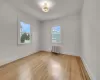 Spare room featuring radiator, a wealth of natural light, and light wood-type flooring