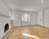 Unfurnished living room with a brick fireplace and light hardwood / wood-style flooring