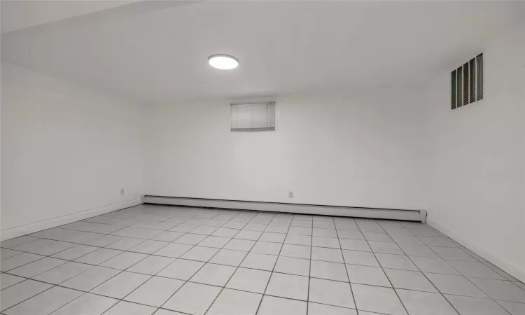 Empty room featuring a baseboard heating unit