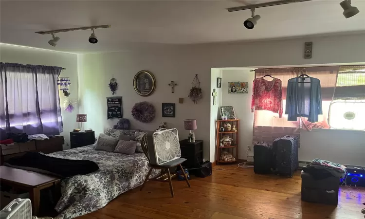 Bedroom with hardwood / wood-style flooring and track lighting