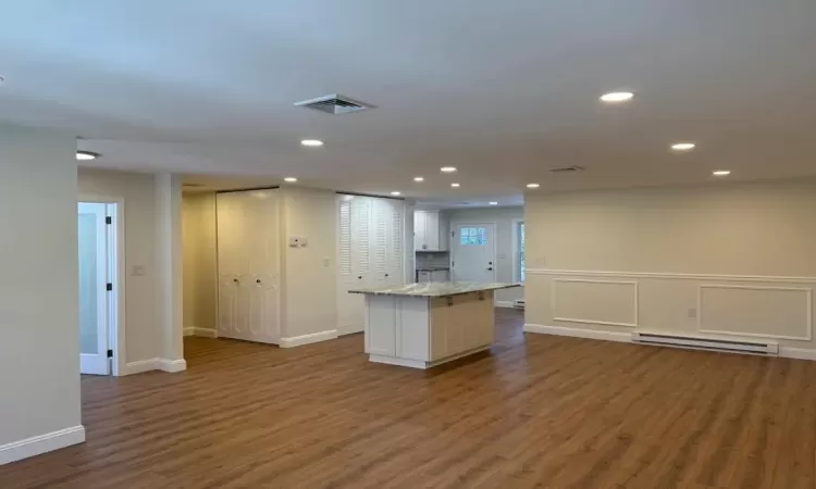 Kitchen featuring baseboard heating, white cabinetry, dark hardwood / wood-style floors, and a kitchen island