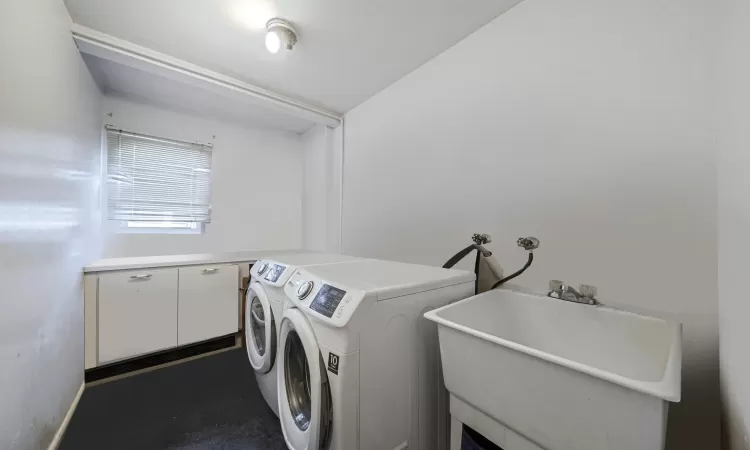 Clothes washing area featuring washer and clothes dryer and sink