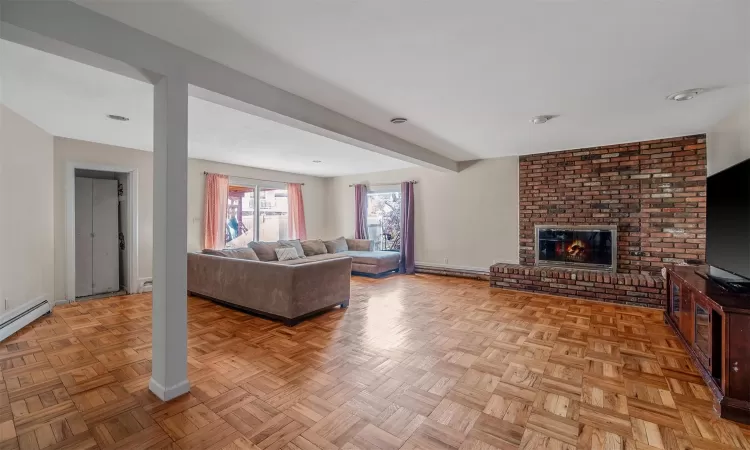 Living room featuring a brick fireplace and light parquet floors