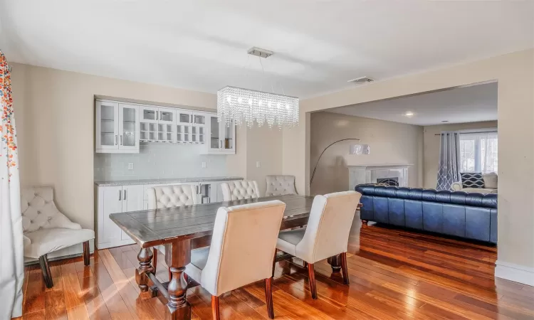 Dining room with dark hardwood / wood-style floors and a notable chandelier