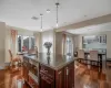 Kitchen featuring a center island with sink, stainless steel microwave, dark hardwood / wood-style flooring, pendant lighting, and sink