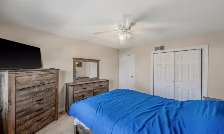 Bedroom with ceiling fan and light colored carpet