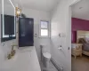 Bathroom with a baseboard heating unit, toilet, and sink