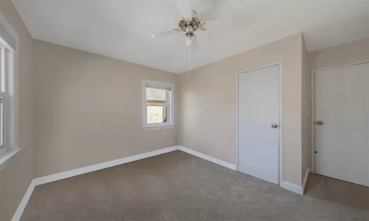 Unfurnished bedroom featuring ceiling fan and carpet flooring