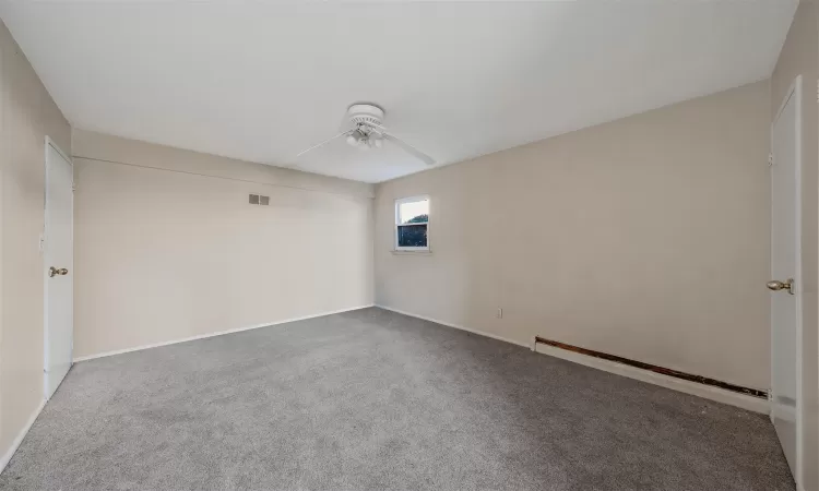 Unfurnished room with carpet, ceiling fan, and a baseboard radiator