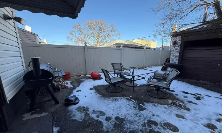 Snow covered patio featuring a grill