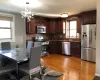 Kitchen with a notable chandelier, stainless steel appliances, a healthy amount of sunlight, and light wood-type flooring