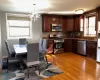 Kitchen with appliances with stainless steel finishes, sink, backsplash, a notable chandelier, and light hardwood / wood-style floors