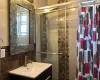 Bathroom with vanity, tile walls, and a shower with shower door