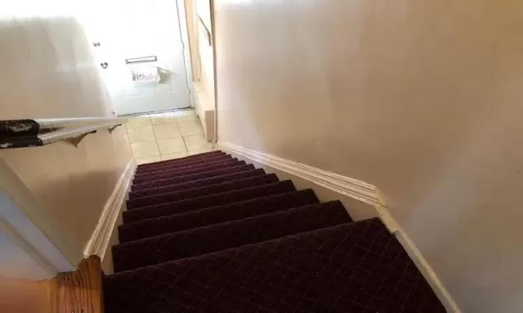 Stairs featuring tile patterned floors