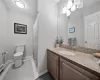 Bathroom with walk in shower, baseboard heating, tile patterned floors, toilet, and vanity