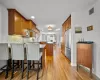 Kitchen with tasteful backsplash, light hardwood / wood-style flooring, kitchen peninsula, stainless steel fridge, and a breakfast bar