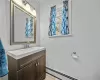 Bathroom featuring vanity, ornamental molding, and a baseboard heating unit