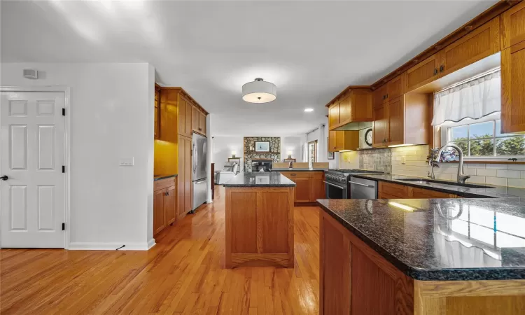 Kitchen with a center island, sink, light hardwood / wood-style flooring, kitchen peninsula, and stainless steel appliances