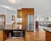 Kitchen featuring backsplash, a kitchen island, light wood-type flooring, and stainless steel appliances