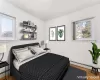 Bedroom with hardwood / wood-style floors and baseboard heating