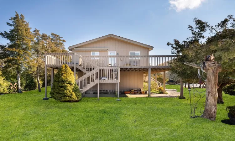 Back of property with a wooden deck and a lawn