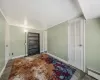 Unfurnished bedroom featuring a baseboard heating unit and dark hardwood / wood-style floors