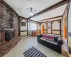 Tiled living room featuring ceiling fan, a baseboard heating unit, a wall mounted air conditioner, a fireplace, and beamed ceiling