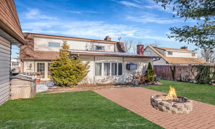 Back of house with a yard, a patio area, and a fire pit