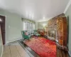 Living room featuring baseboard heating, tile patterned flooring, and a brick fireplace