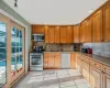 Kitchen with sink, decorative backsplash, light tile patterned flooring, and appliances with stainless steel finishes