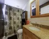 Bathroom featuring tasteful backsplash, tile walls, vanity, a baseboard heating unit, and toilet