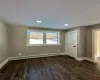 Unfurnished room with a baseboard heating unit and dark hardwood / wood-style floors