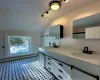 Bathroom with lofted ceiling, vanity, and a baseboard heating unit