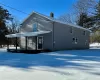 Snow covered property with a porch